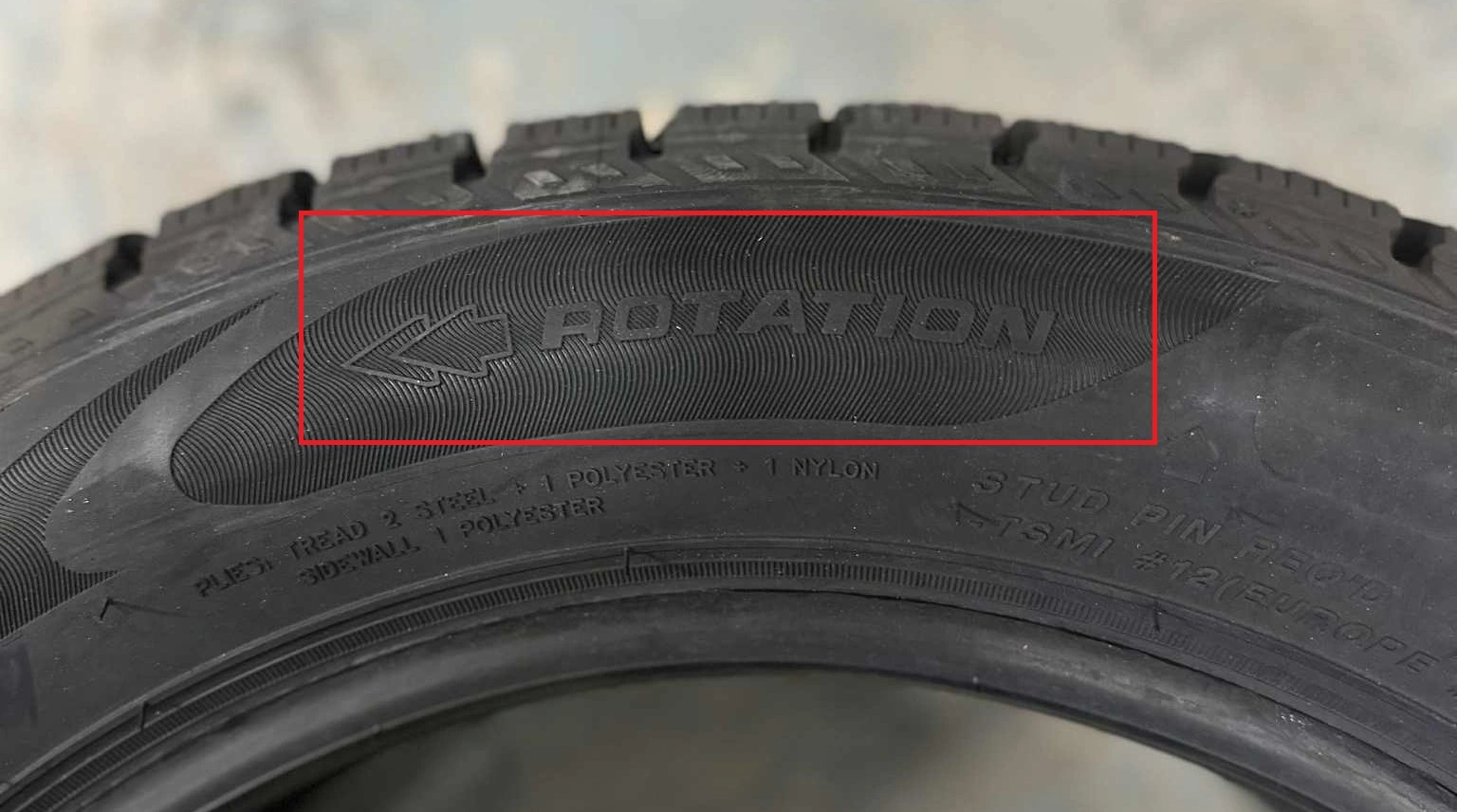 ROTATION-markering och pil på däcksidan som visar däckets rotationsriktning